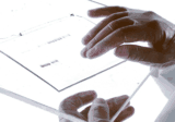 Gloved hands holding a DNA gel on a light box